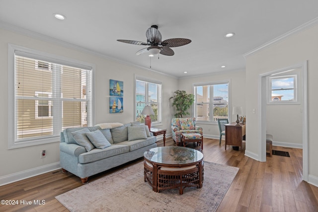 living room featuring a wealth of natural light, crown molding, ceiling fan, and wood-type flooring