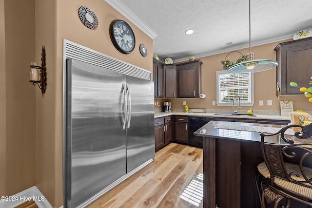 kitchen with sink, hanging light fixtures, light hardwood / wood-style floors, dark brown cabinetry, and stainless steel built in fridge