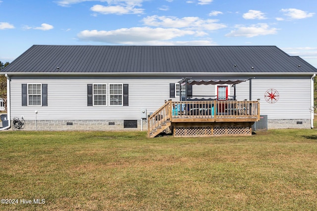 rear view of property featuring a wooden deck and a yard