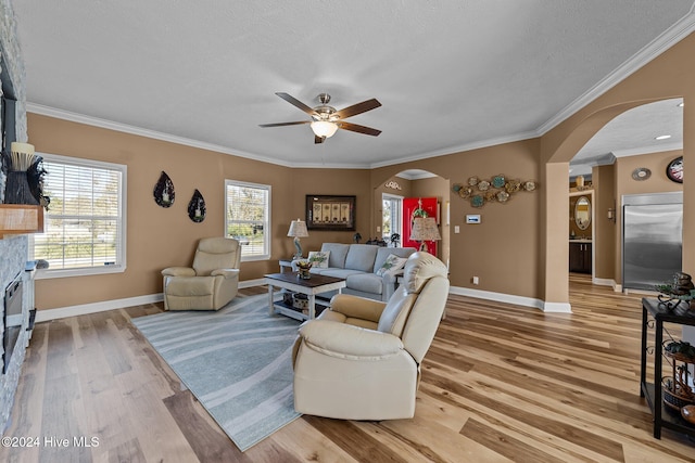 living room featuring ceiling fan, crown molding, a textured ceiling, and hardwood / wood-style floors