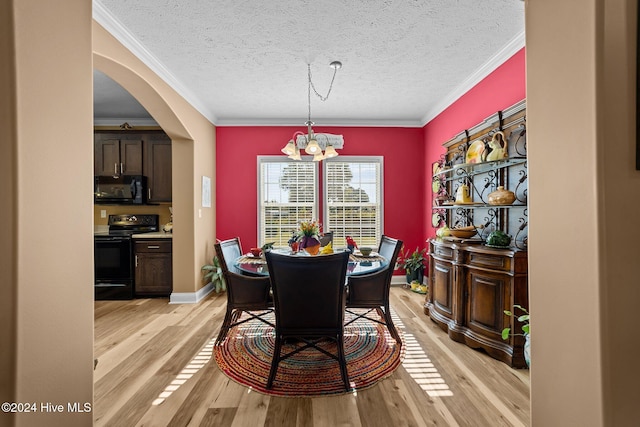 dining room with crown molding, a textured ceiling, an inviting chandelier, and light wood-type flooring