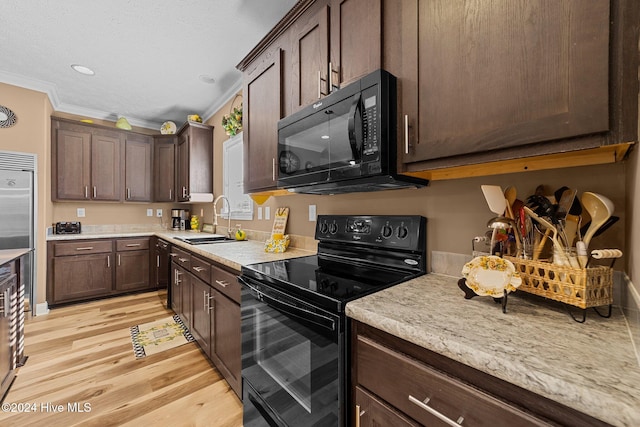 kitchen with light hardwood / wood-style flooring, dark brown cabinets, ornamental molding, sink, and black appliances