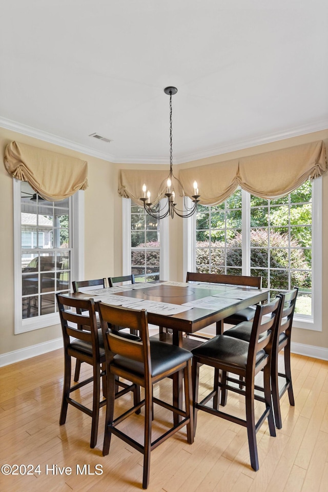 1109 Foxbow Cv, Leland, NC 28451 - dining room with a chandelier, ornamental molding, plenty of natural light, and light wood-type flooring