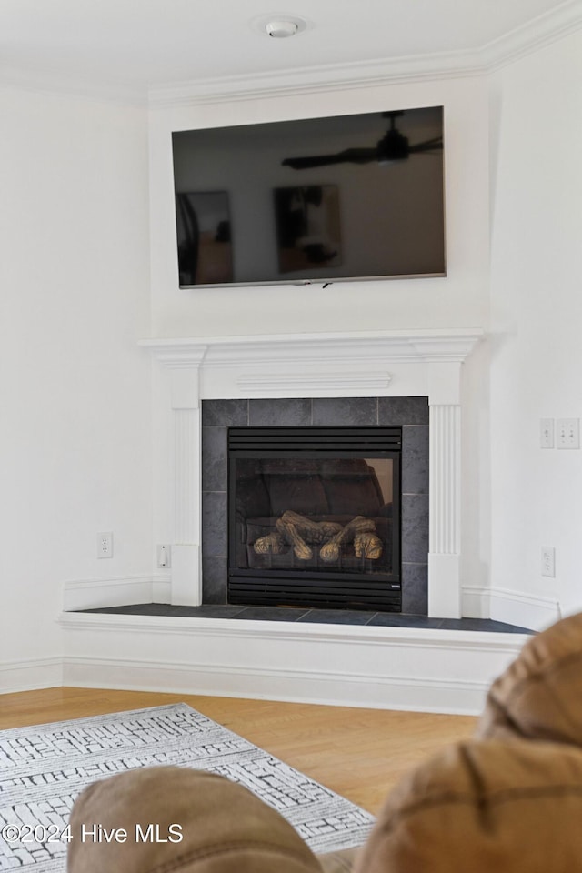 1109 Foxbow Cv, Leland, NC 28451 - detailed view of wood finished floors, a tiled fireplace, and crown molding