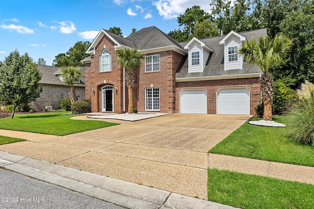 1109 Foxbow Cv, Leland, NC 28451 - view of front facade with concrete driveway, brick siding, a front yard, and roof with shingles