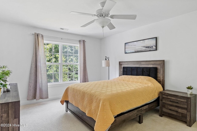 1109 Foxbow Cv, Leland, NC 28451 - bedroom with light carpet, a ceiling fan, and a fireplace