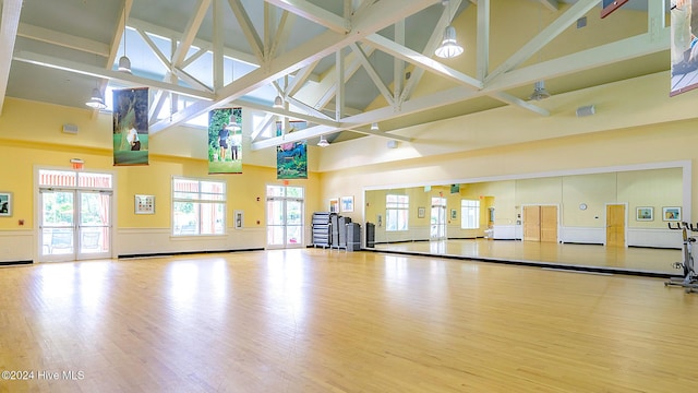 1109 Foxbow Cv, Leland, NC 28451 - exercise room with high vaulted ceiling, wood finished floors, and a wainscoted wall