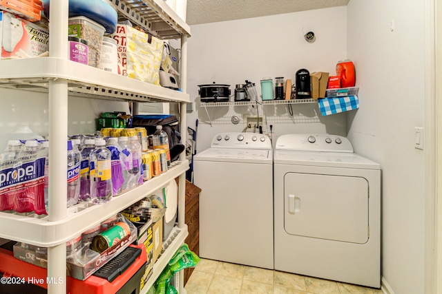 clothes washing area with a textured ceiling and washing machine and dryer