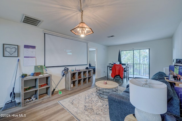 living room with a chandelier and light hardwood / wood-style floors