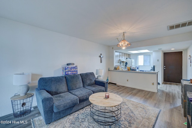 living room featuring light hardwood / wood-style floors and a notable chandelier