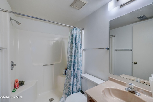 bathroom with toilet, vanity, and a shower with shower curtain