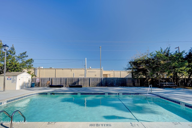 view of swimming pool featuring a storage shed