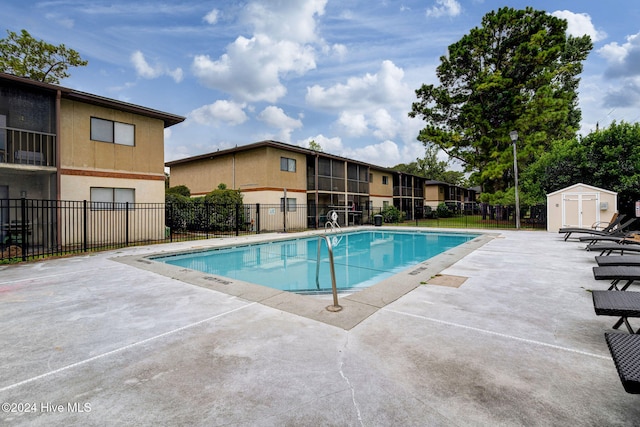 view of pool featuring a storage shed and a patio area