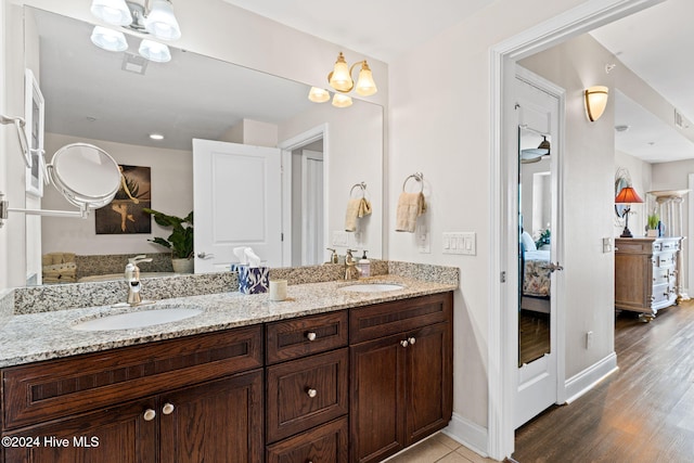 bathroom featuring vanity, wood-type flooring, and an inviting chandelier