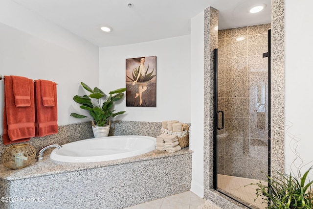 bathroom featuring tile patterned flooring and separate shower and tub