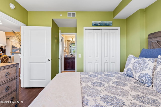 bedroom featuring dark hardwood / wood-style flooring, ensuite bath, and a closet