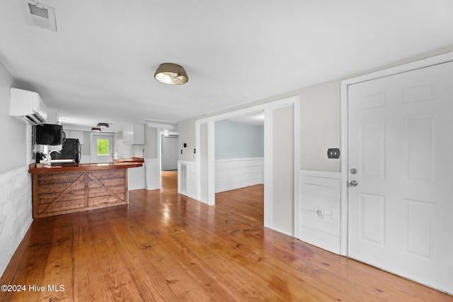 interior space featuring an AC wall unit, sink, and hardwood / wood-style floors