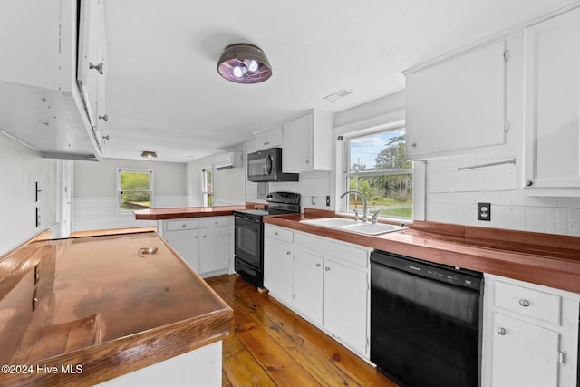 kitchen featuring wood-type flooring, black appliances, sink, and plenty of natural light