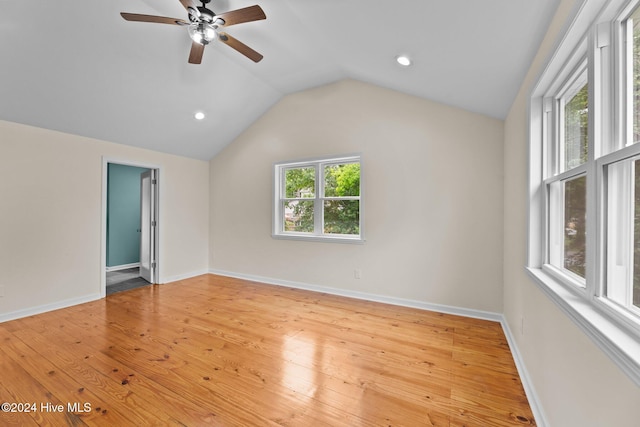 empty room with a healthy amount of sunlight, lofted ceiling, and light hardwood / wood-style flooring