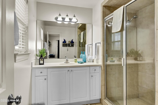 bathroom with vanity, an enclosed shower, and plenty of natural light