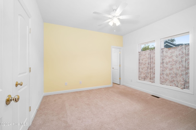 carpeted spare room with ceiling fan