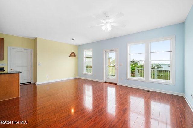 unfurnished living room with ceiling fan and dark hardwood / wood-style flooring