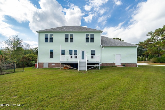 rear view of house featuring a yard and a wooden deck