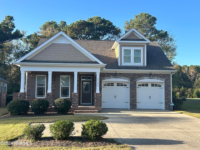 craftsman inspired home featuring a front yard, covered porch, and a garage