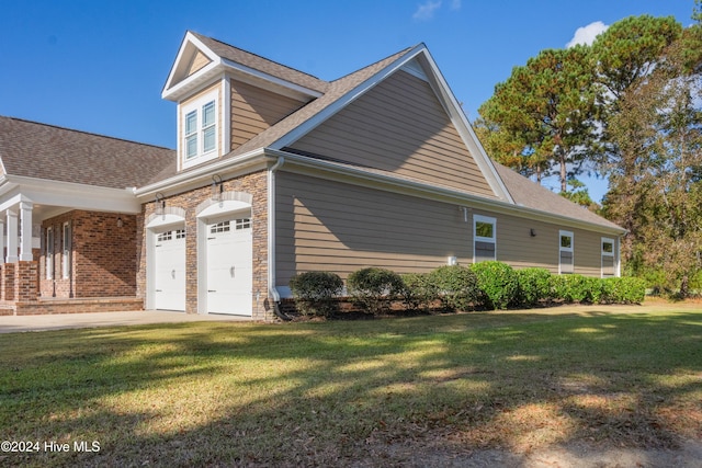 view of side of home with a yard and a garage