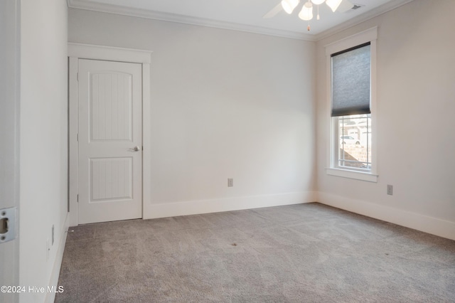 empty room featuring ornamental molding, carpet, and ceiling fan