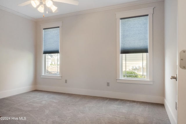 empty room with light carpet, ornamental molding, ceiling fan, and a wealth of natural light