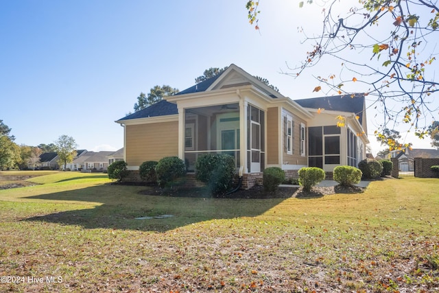 view of side of home with a yard and a sunroom