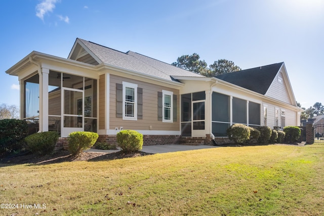 back of house with a sunroom and a lawn