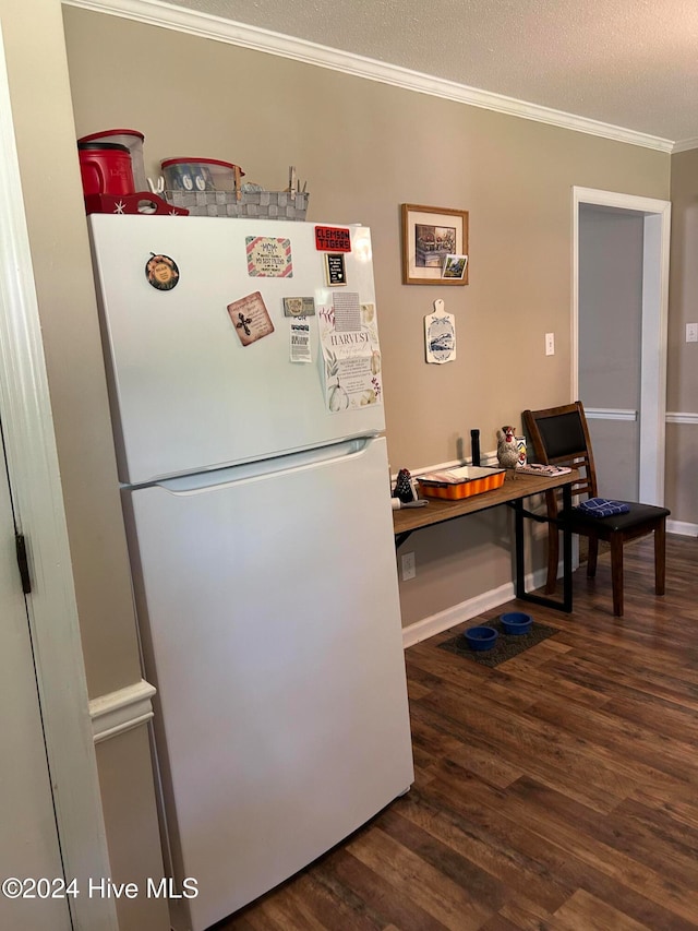 kitchen with a textured ceiling, ornamental molding, dark hardwood / wood-style flooring, and white refrigerator