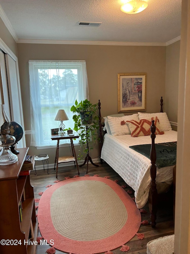 bedroom featuring crown molding, a textured ceiling, and dark wood-type flooring