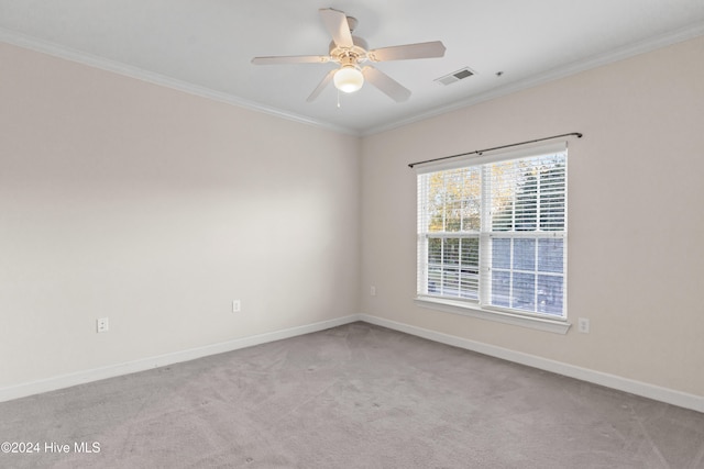 carpeted empty room featuring ceiling fan and crown molding