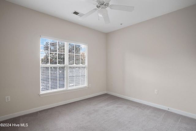 carpeted spare room with ceiling fan