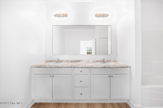 34 Bless Ave, Bolton, NC 28423 - full bath featuring double vanity, wood finished floors, and baseboards