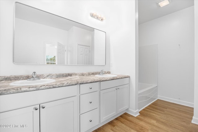 34 Bless Ave, Bolton, NC 28423 - bathroom featuring wood finished floors, baseboards, double vanity, and a bathtub