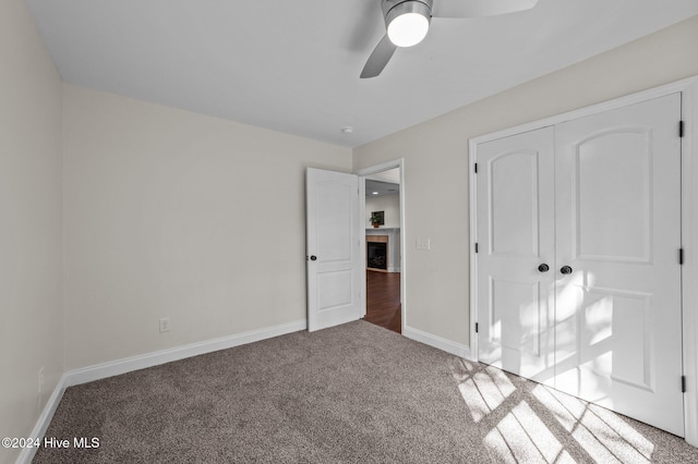 unfurnished bedroom with a closet, carpet floors, and ceiling fan