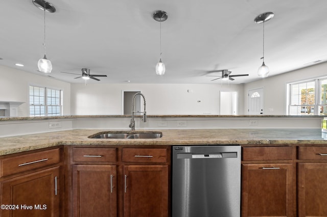 kitchen featuring stainless steel dishwasher, sink, and decorative light fixtures