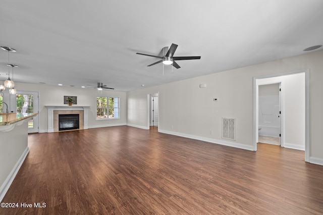 unfurnished living room with dark hardwood / wood-style floors, a fireplace, and a wealth of natural light