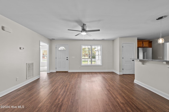 unfurnished living room featuring ceiling fan and dark hardwood / wood-style flooring