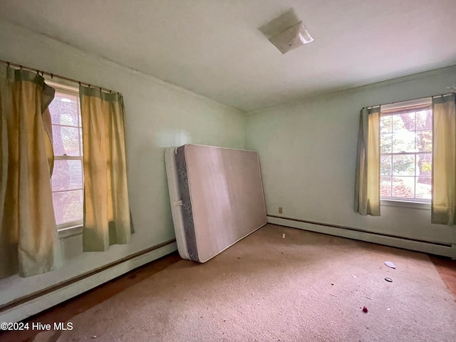 unfurnished room featuring baseboard heating and light carpet