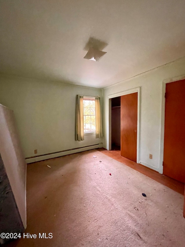 unfurnished bedroom with carpet and a baseboard radiator