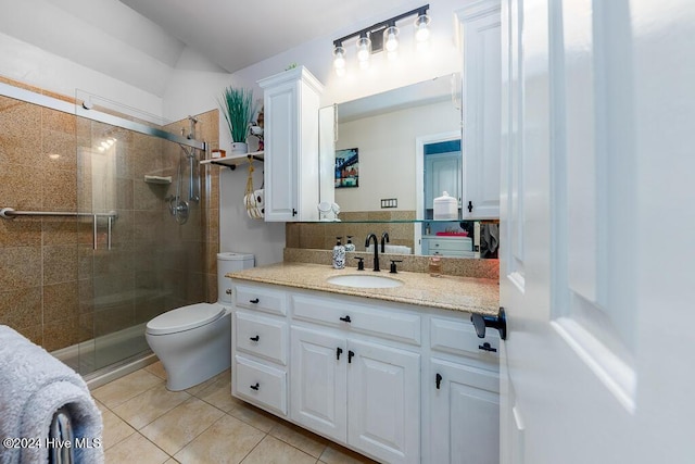 bathroom with vanity, a shower stall, toilet, and tile patterned floors