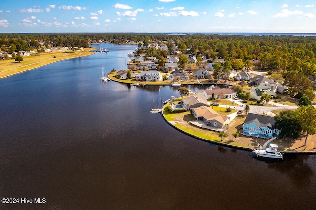 drone / aerial view with a water view, a residential view, and a view of trees