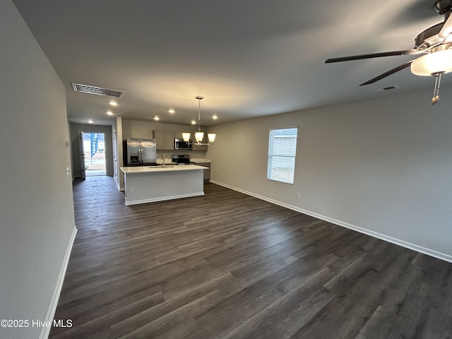 unfurnished living room with dark hardwood / wood-style floors, sink, and ceiling fan with notable chandelier