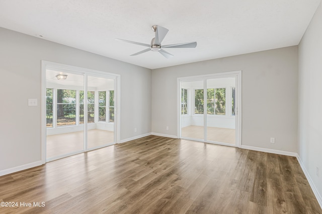 unfurnished room featuring ceiling fan, hardwood / wood-style flooring, and plenty of natural light