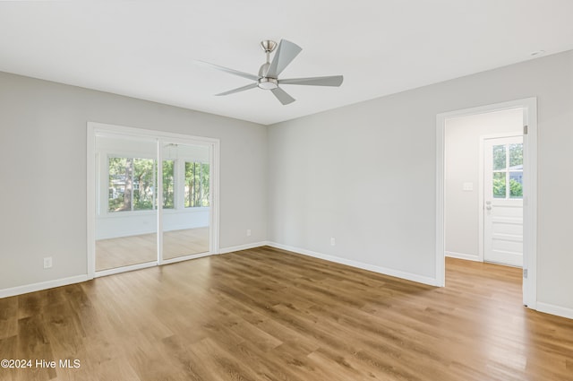 spare room with wood-type flooring, plenty of natural light, and ceiling fan